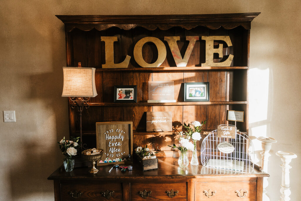 Wedding guestbook and cards table with LOVE letters and floral decor