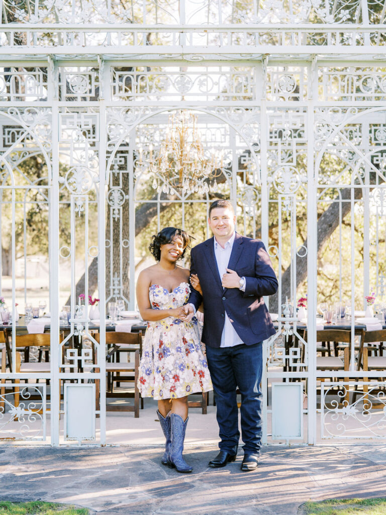 A couple walks arm in arm at an outdoor venue, showcasing Engagement Party Etiquette in 2026