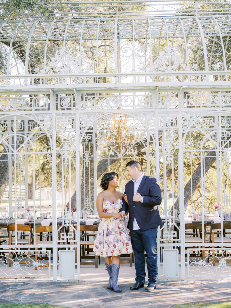 A couple stands together under a white gazebo, highlighting Engagement Party Etiquette in 2026