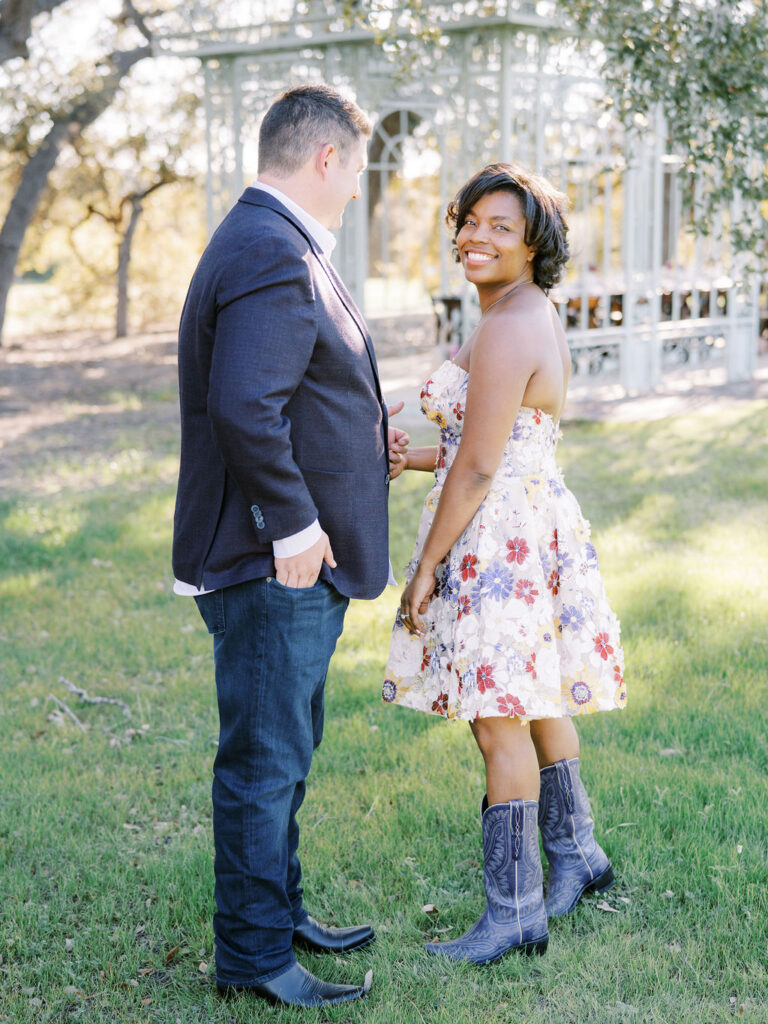A couple turns toward each other with joyful expressions, portraying Engagement Party Etiquette in 2026