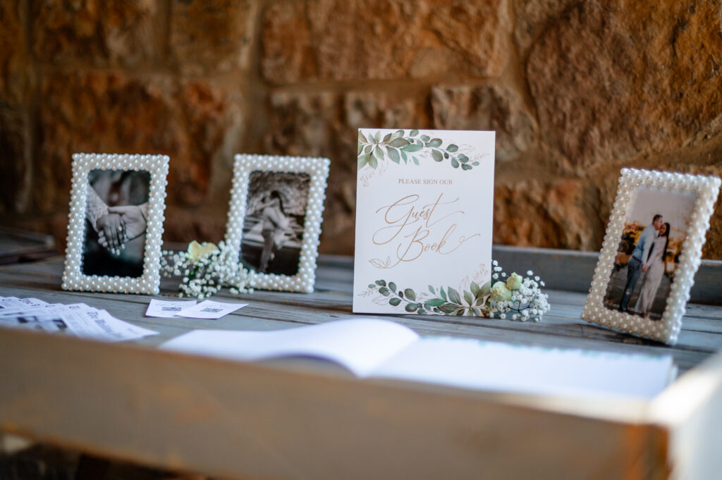 Wedding guestbook table with framed couple photos and floral sign