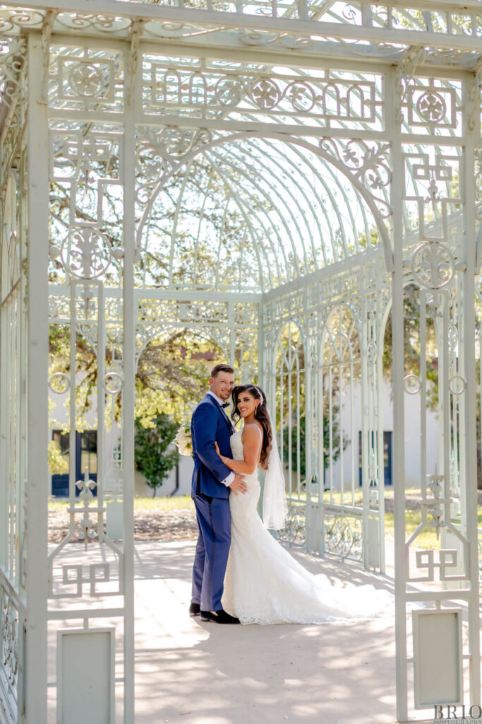 bride and groom standing in greenhouse at Ma Maison