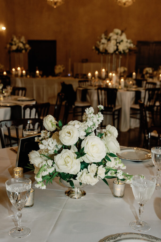 White rose wedding centerpiece on an elegant reception table.