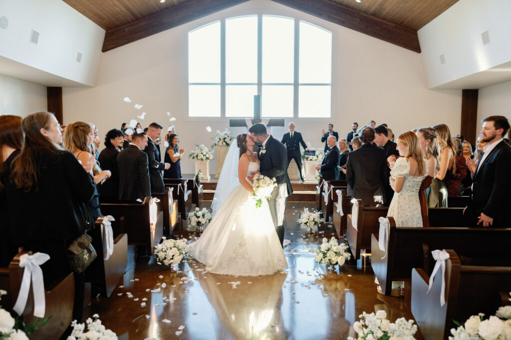 Married couple kiss in the aisle
