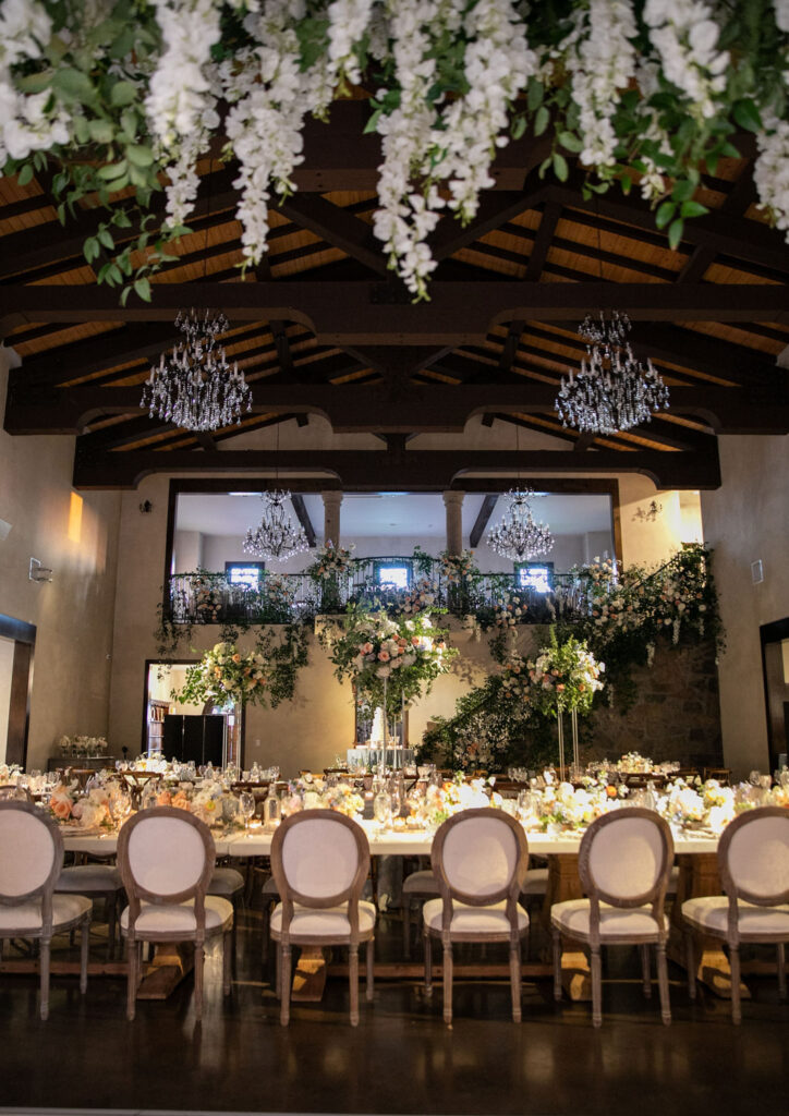 Chandeliers and lush floral decor inside an Austin wedding venue with European elegance