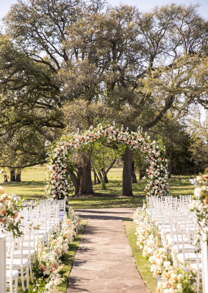 Outdoor ceremony aisle lined with florals at an Austin wedding venue