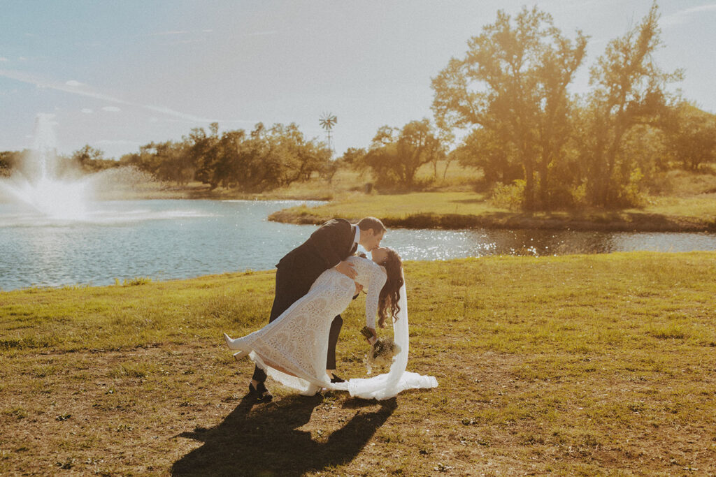 bride and groom kissing at pond at Ma Maison wedding venue