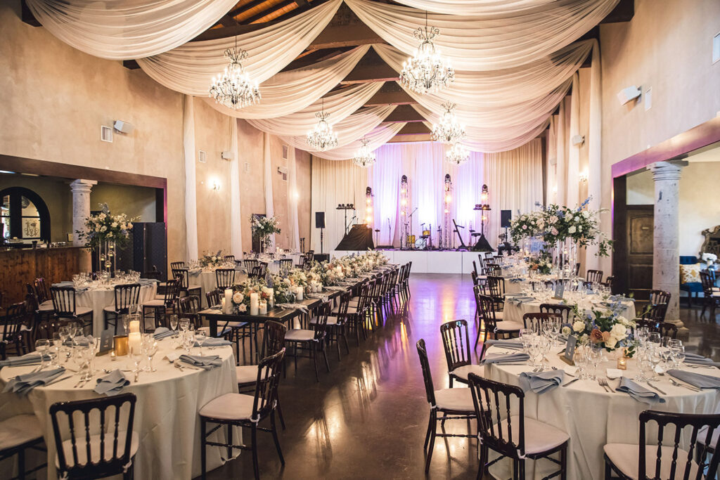 Draped ceilings, chandeliers, and elegant table settings make Ma Maison’s Great Hall the ultimate indoor reception space.