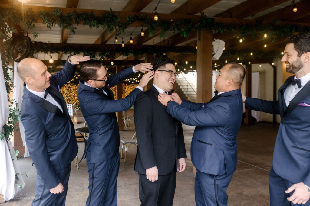 A groom and his groomsmen pose in Ma Maison’s covered outdoor space, ensuring comfort on a rainy wedding day.