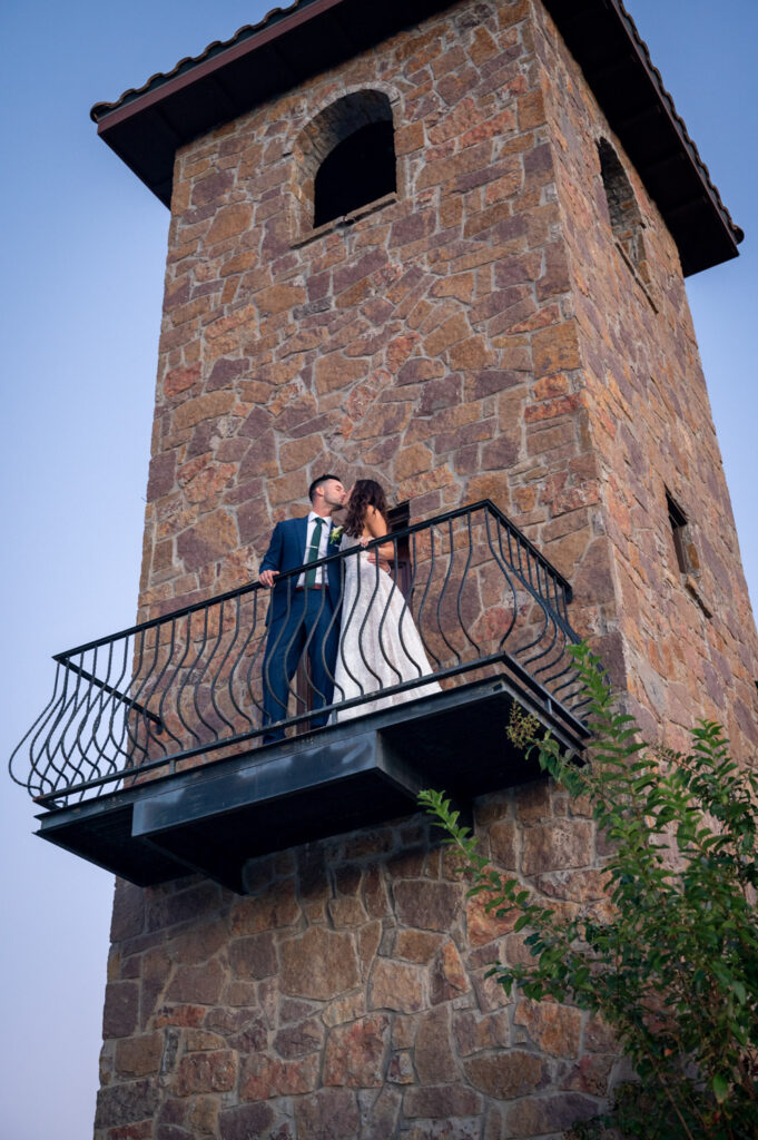 Romantic kiss on stone tower balcony at the Best Non-Barn Wedding Venues