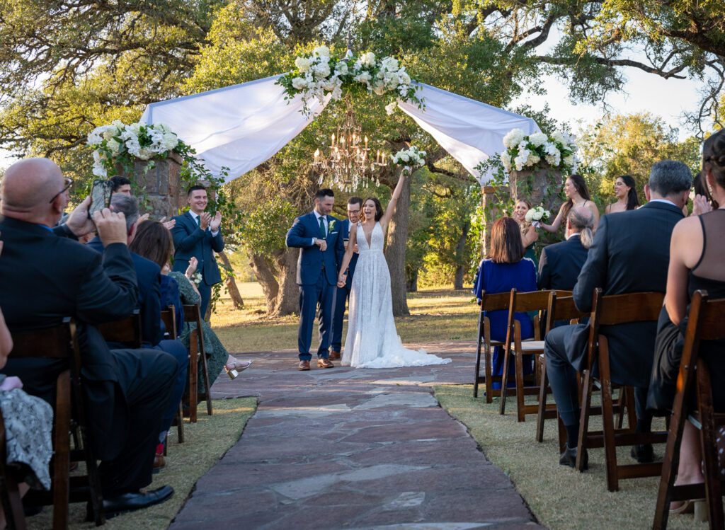 Couple celebrating ceremony with floral arch
