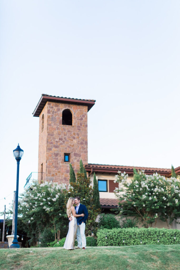 Couple kissing in front of Ma Maison stone tower, best place to propose in Austin