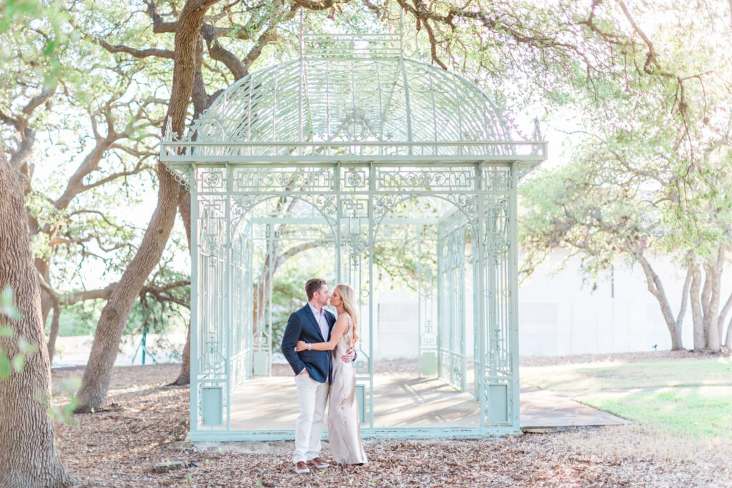Couple sharing a kiss at Ma Maison’s French gazebo, best place to propose in Austin