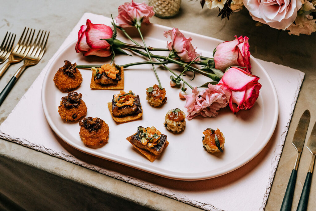 A stunning appetizer platter with gourmet bites and fresh roses