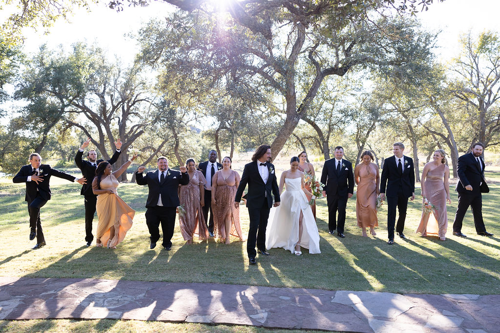 Wedding party walking outdoors in formal tuxedos and gowns at black-tie wedding
