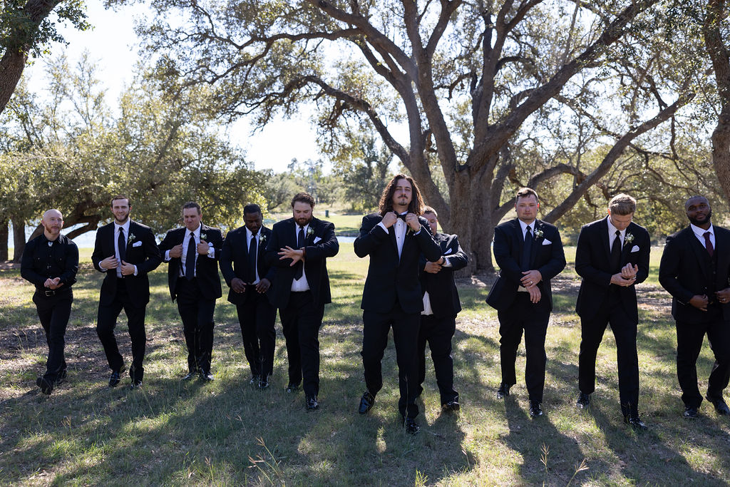 Groomsmen adjusting tuxedos for a classic black-tie wedding look