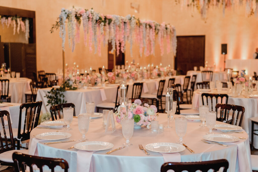 Reception table with pastel floral centerpiece and hanging flowers