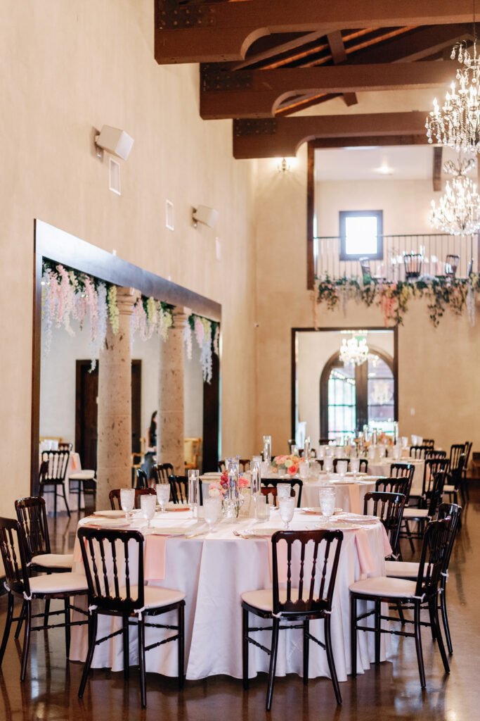 Elegant wedding reception room with round tables and black chairs