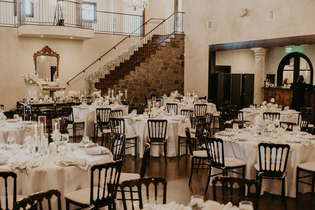 Wedding reception hall at Ma Maison styled with white linens and candlelight.