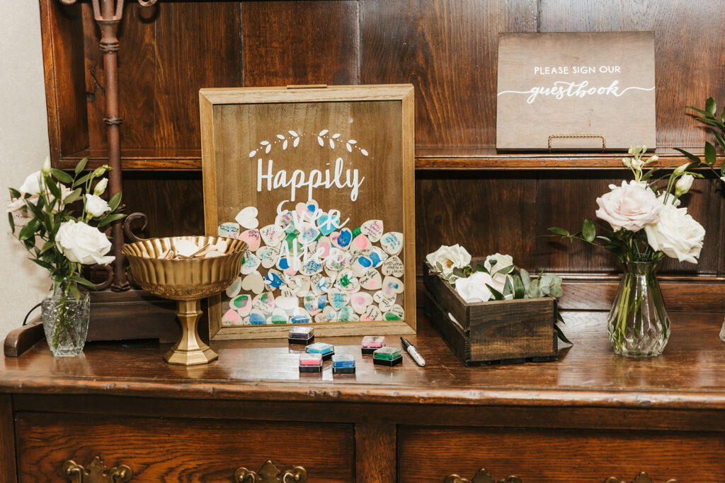 Wooden wedding guestbook display with heart-shaped message pieces