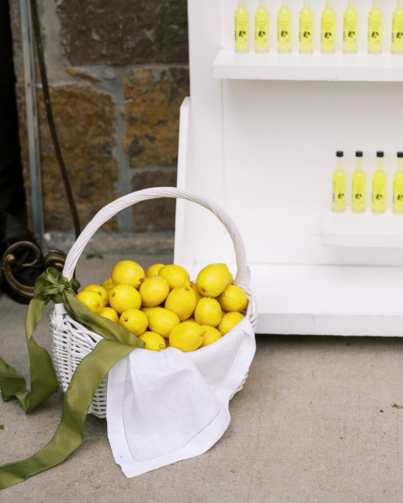 Basket filled with fresh lemons beside a wedding favor display.