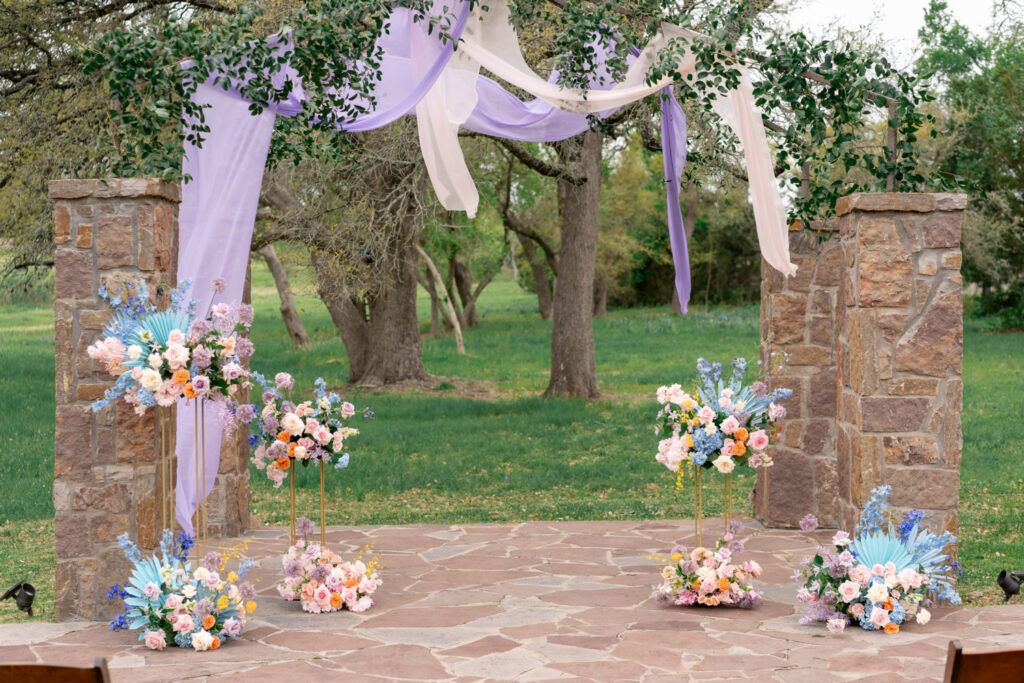 Outdoor ceremony space with pastel florals and lavender draping