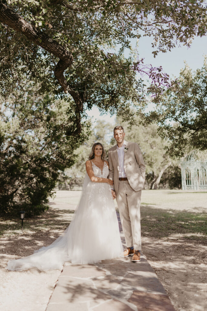 Bride and groom holding hands under oak trees Fall 2026 Wedding Trends