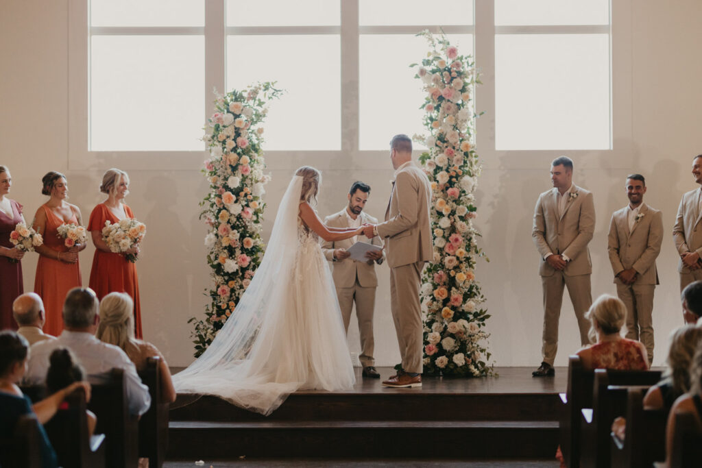 Indoor wedding ceremony with floral arches Fall 2026 Wedding Trends