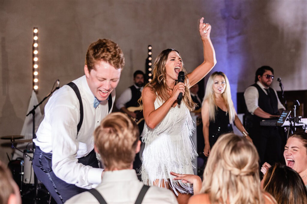 bride singing through a microphone on wedding day