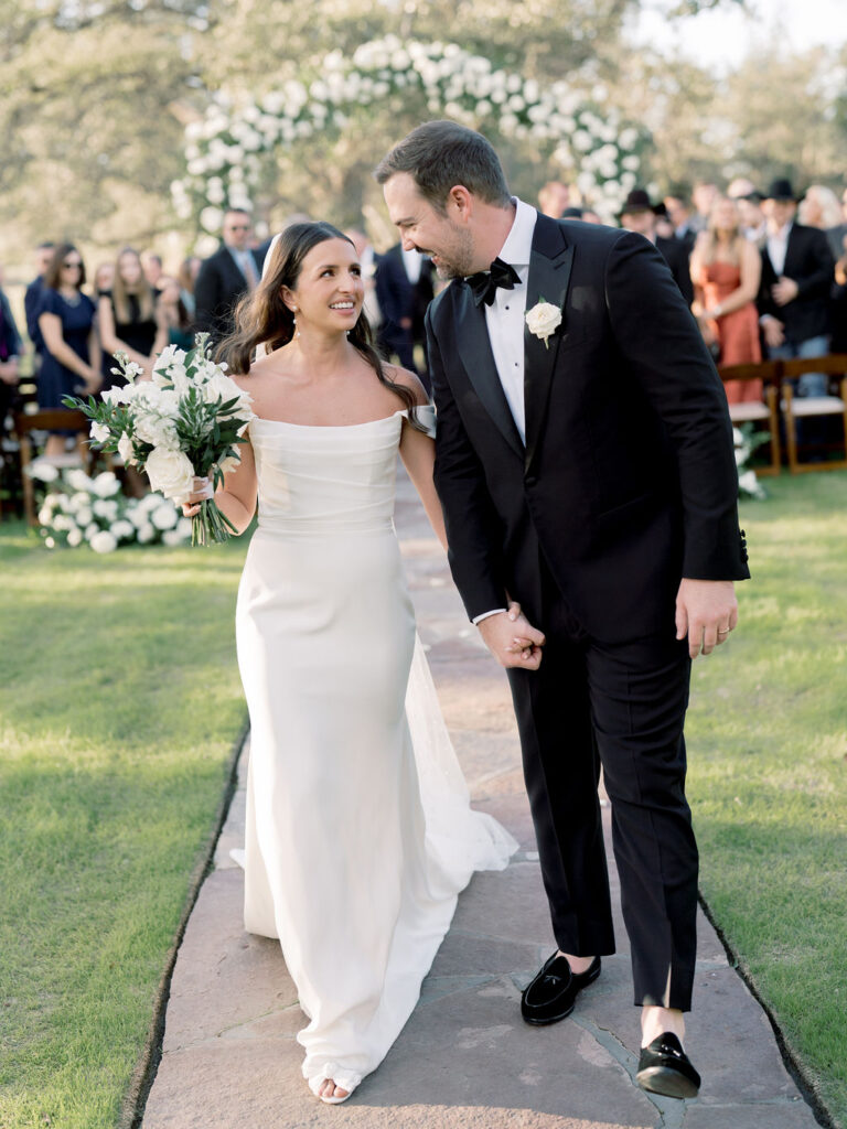 Couple walking down aisle smiling