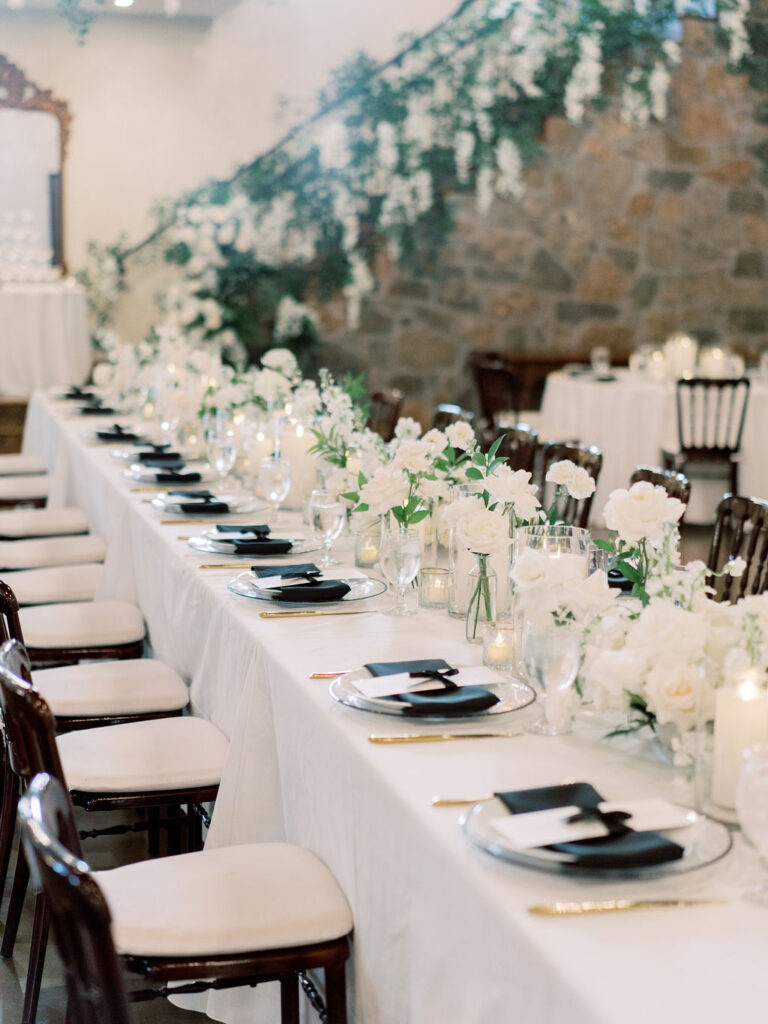 Long banquet table with white florals at Houston weddings