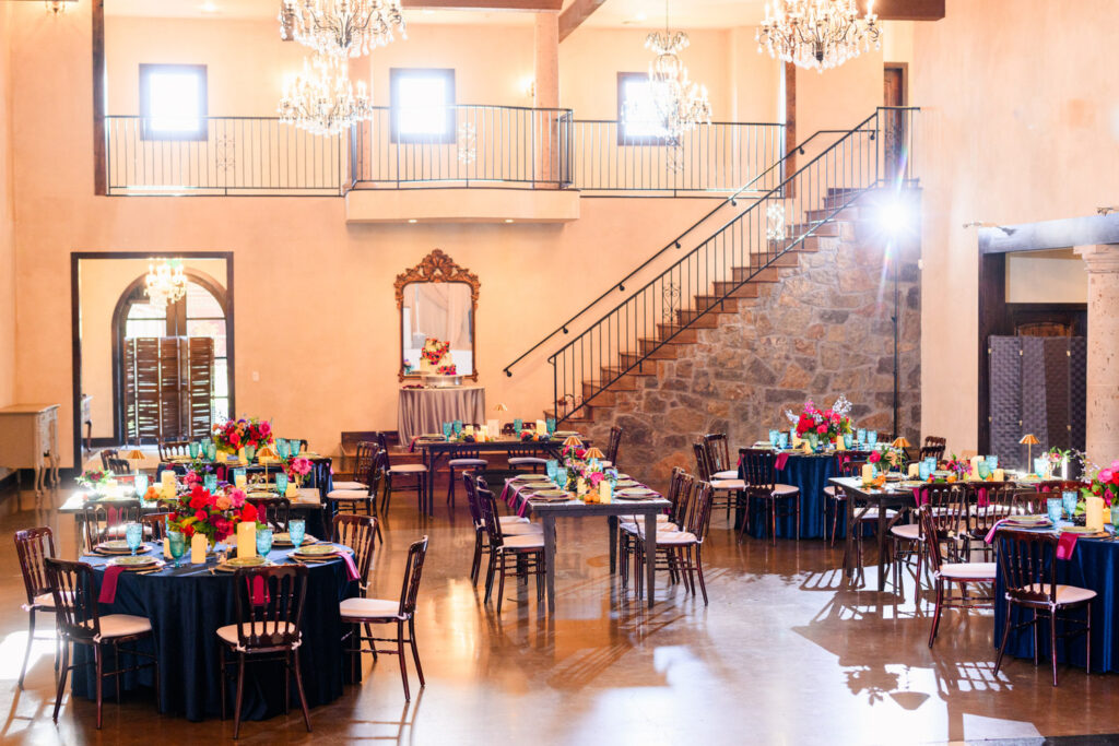 Wide view of decorated reception tables inside an intimate wedding venue