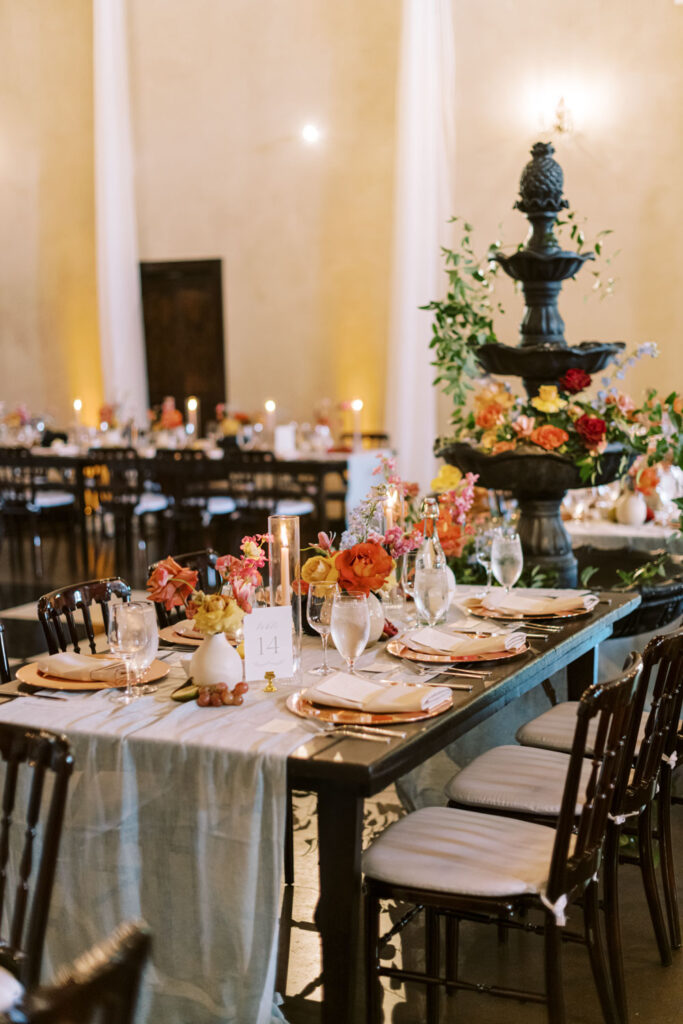 An elegant wedding reception setup at Ma Maison, a Tuscan Destination Wedding Venue, featuring candlelit tables, lush floral arrangements, and European charm