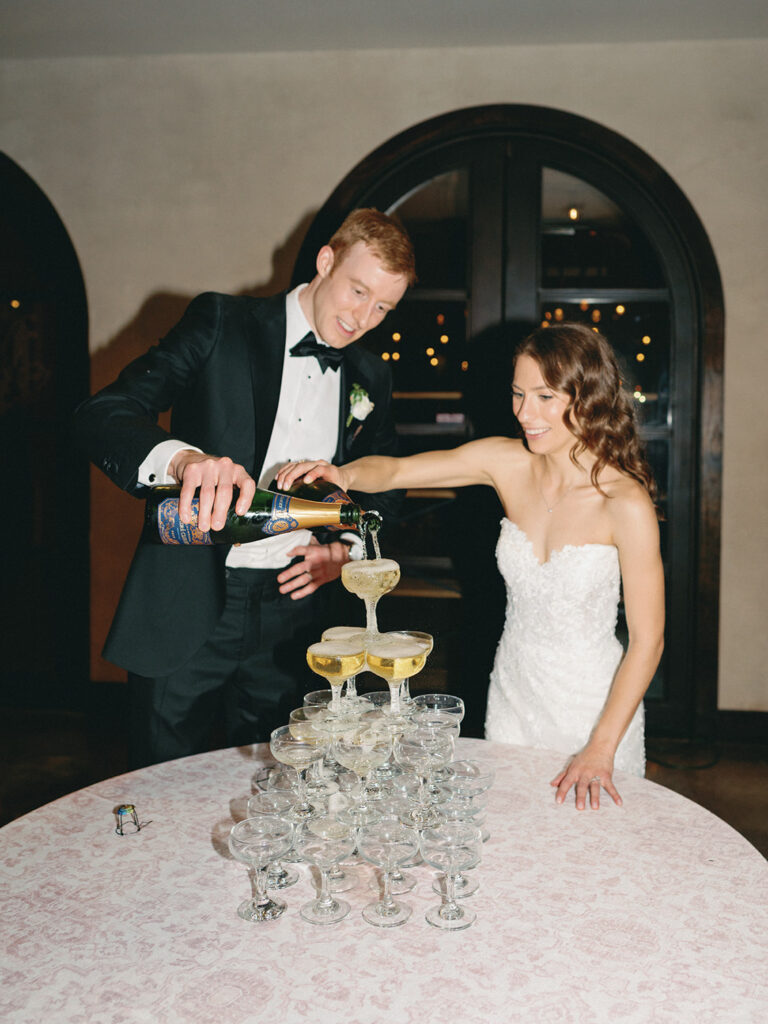bride and groom pouring champagne into champagne tower at Ma Maison
