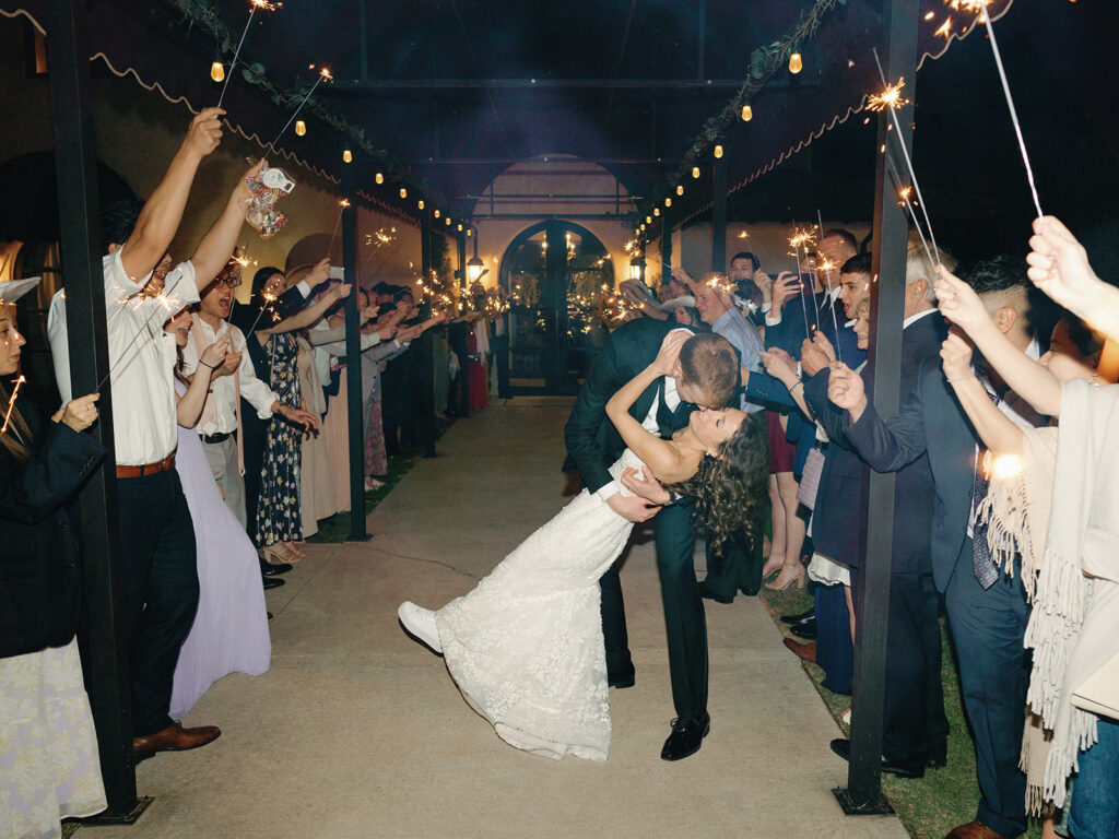 couple kissing in wedding exit of sparklers
