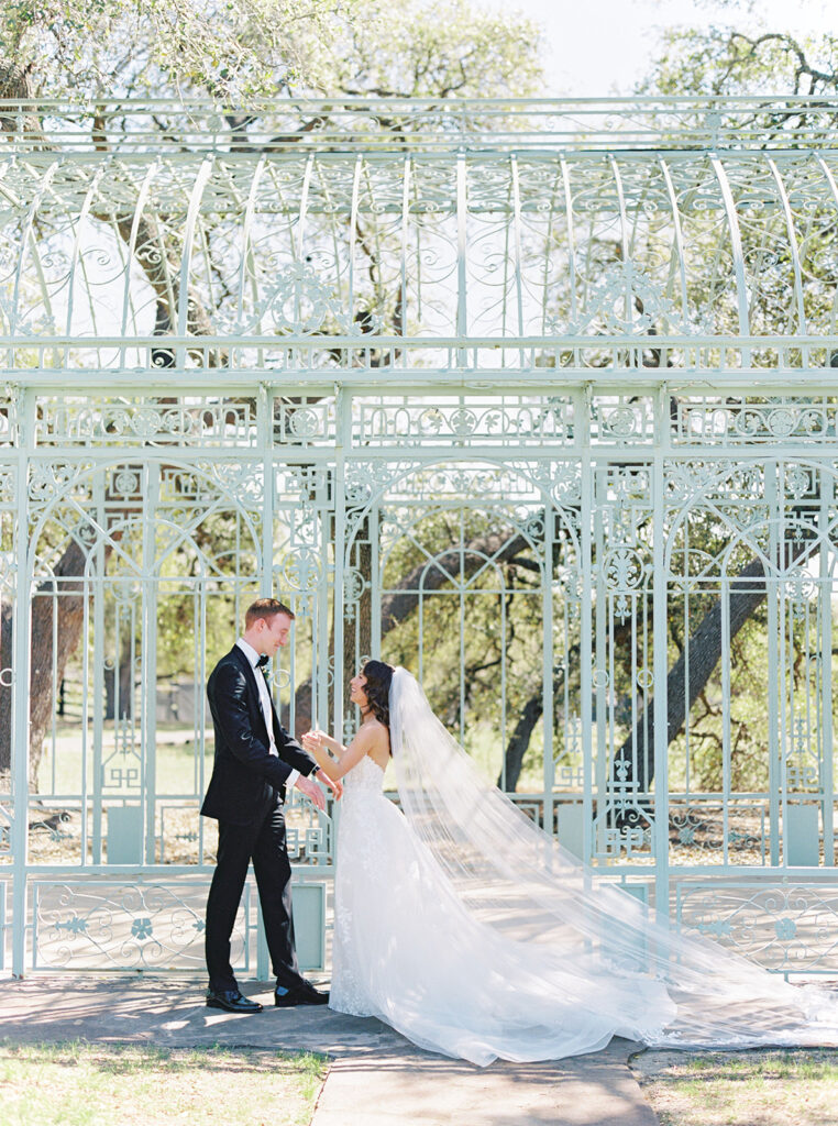 bride and groom standing in front of greenhouse at Ma Maison wedding venue