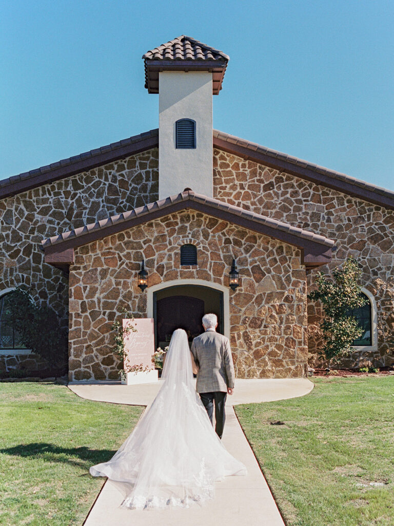 bride and father of the bride walking toward chapel at Ma Maison wedding venue