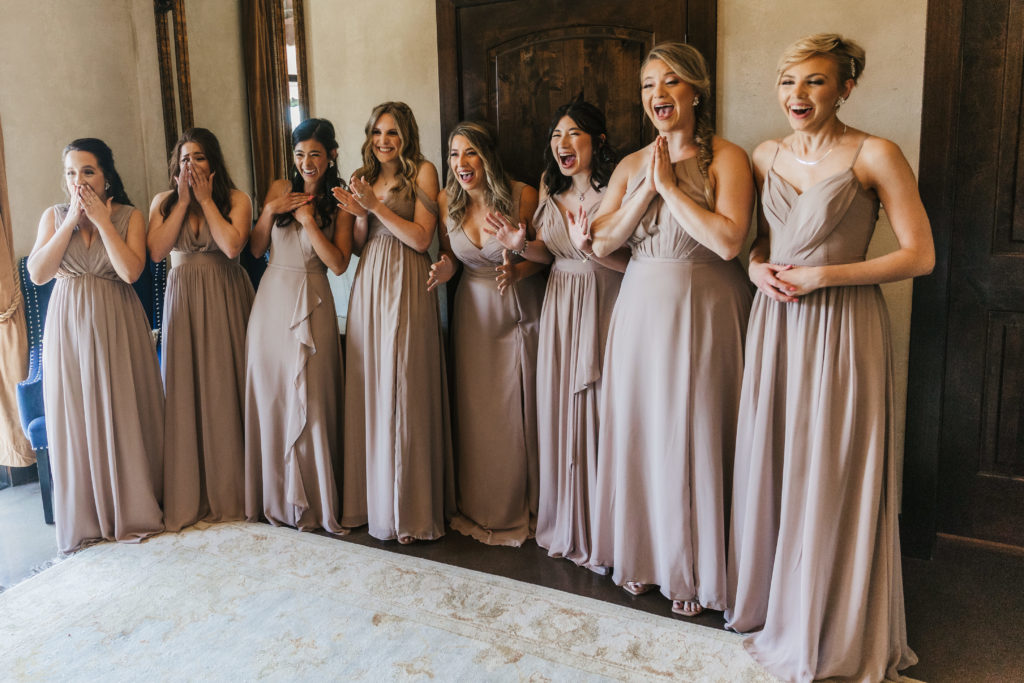 bridesmaids smiling as bride reveals her dress at Austin Texas wedding venue