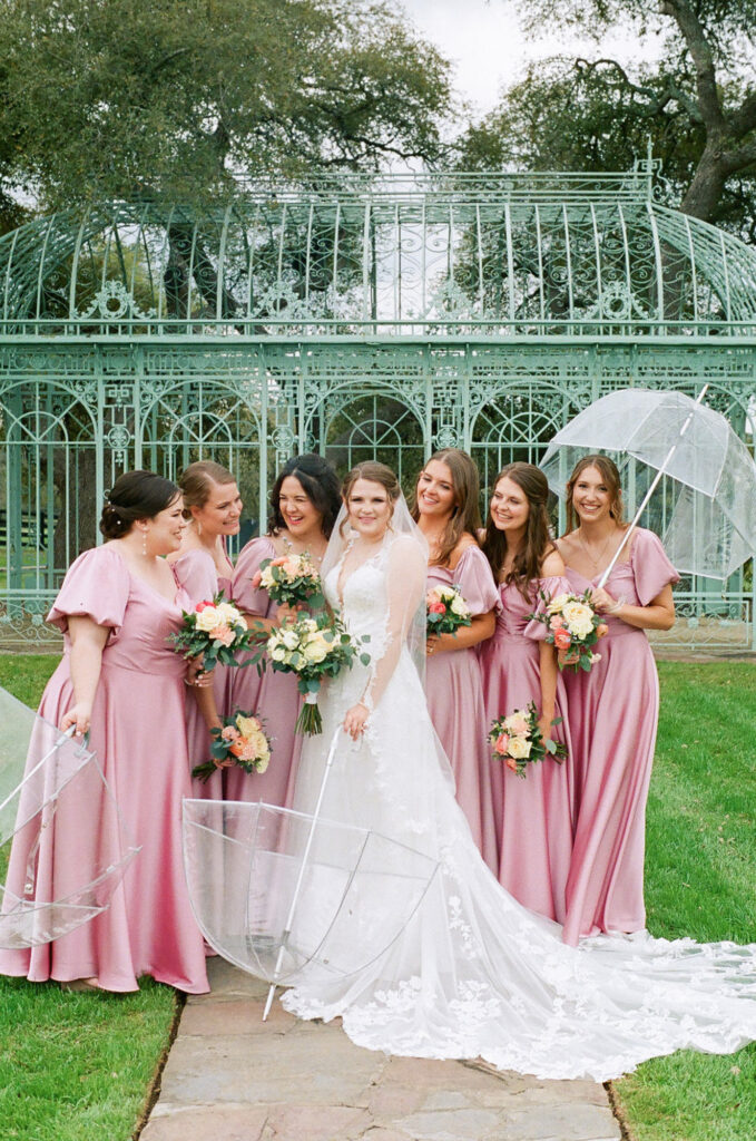 Kelsey and her bridal party dressed in pink at Ma Maison, a wedding venue in TX