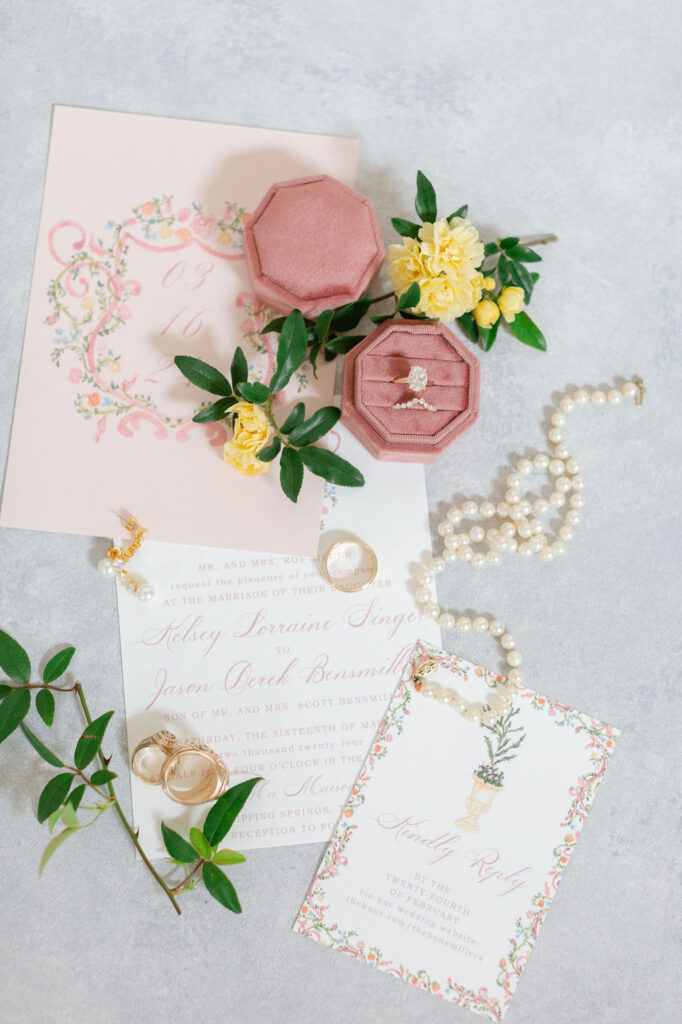 flatlay of jewelry and flowers and invitations 
