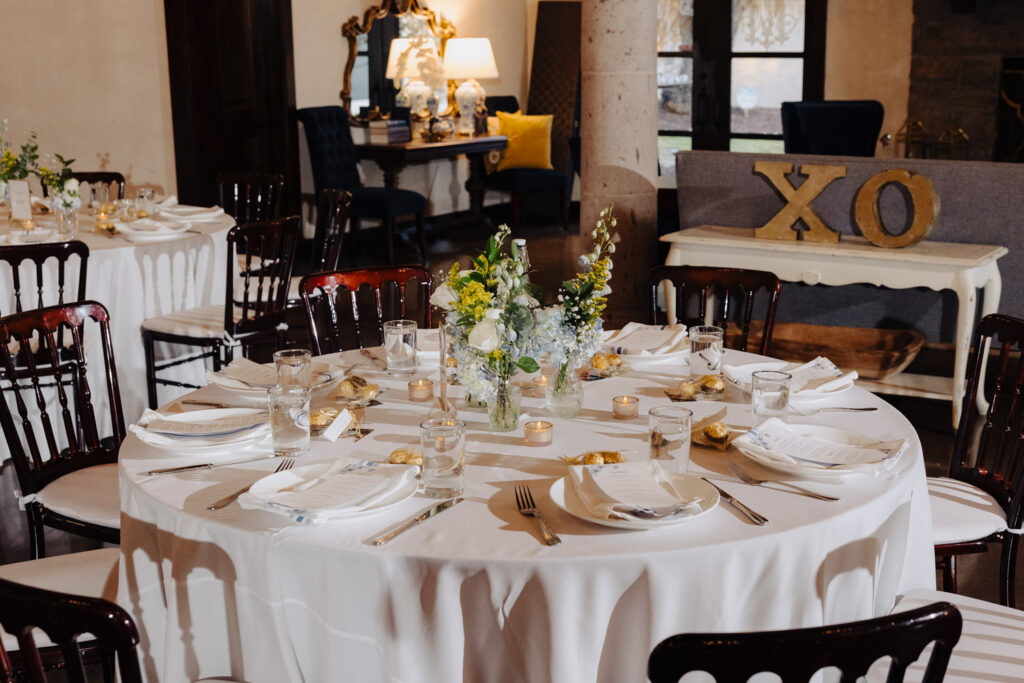 Reception table with white linens and floral centerpiece
