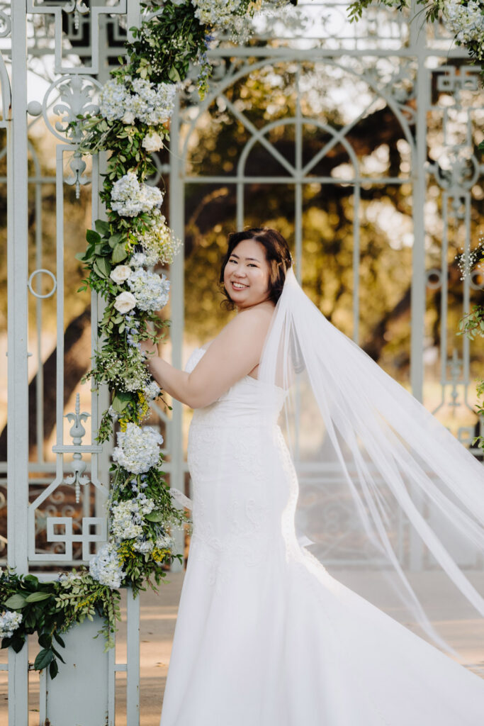 Woman in a white wedding dress beside blue and white florals