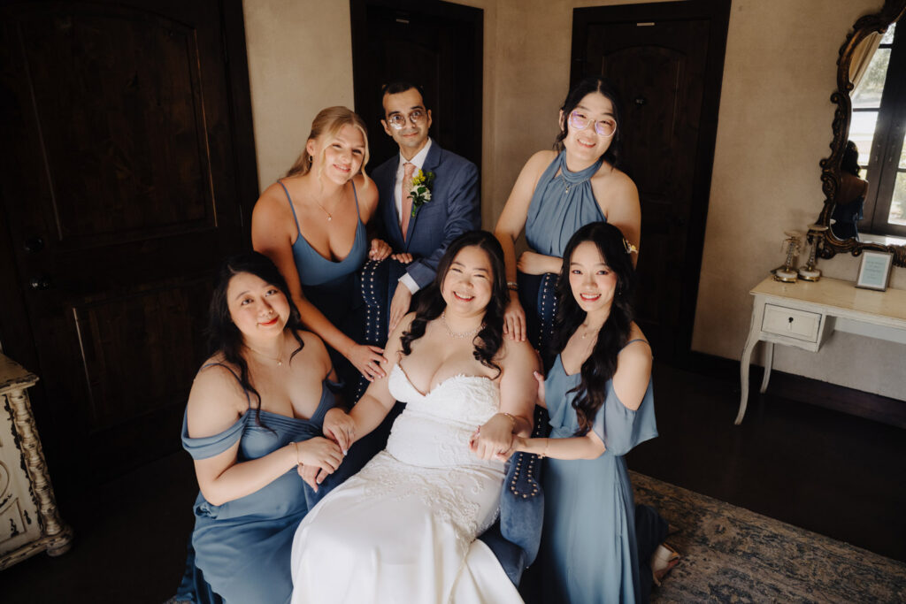 Wedding party posing indoors in blue dresses and navy suits