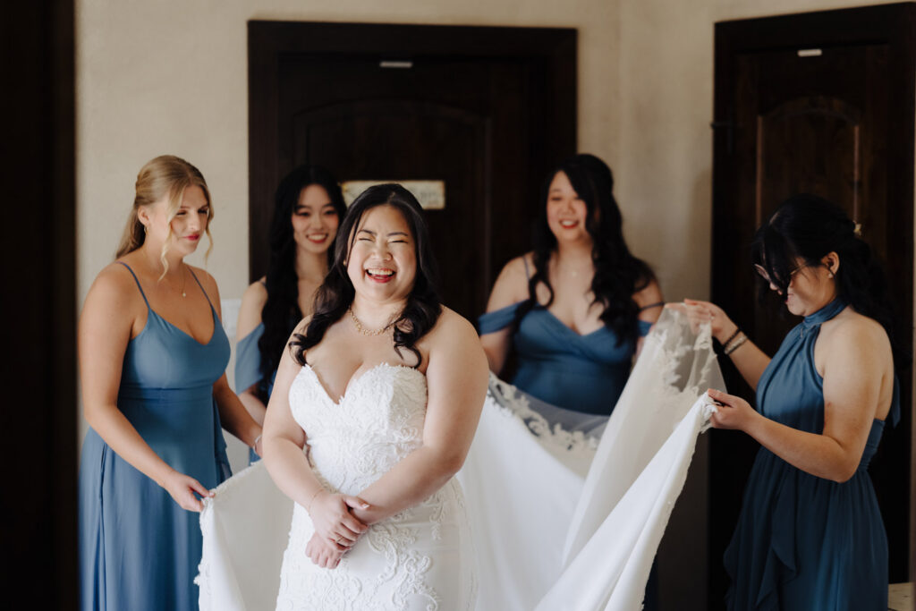 Woman in a white wedding dress surrounded by bridesmaids in blue