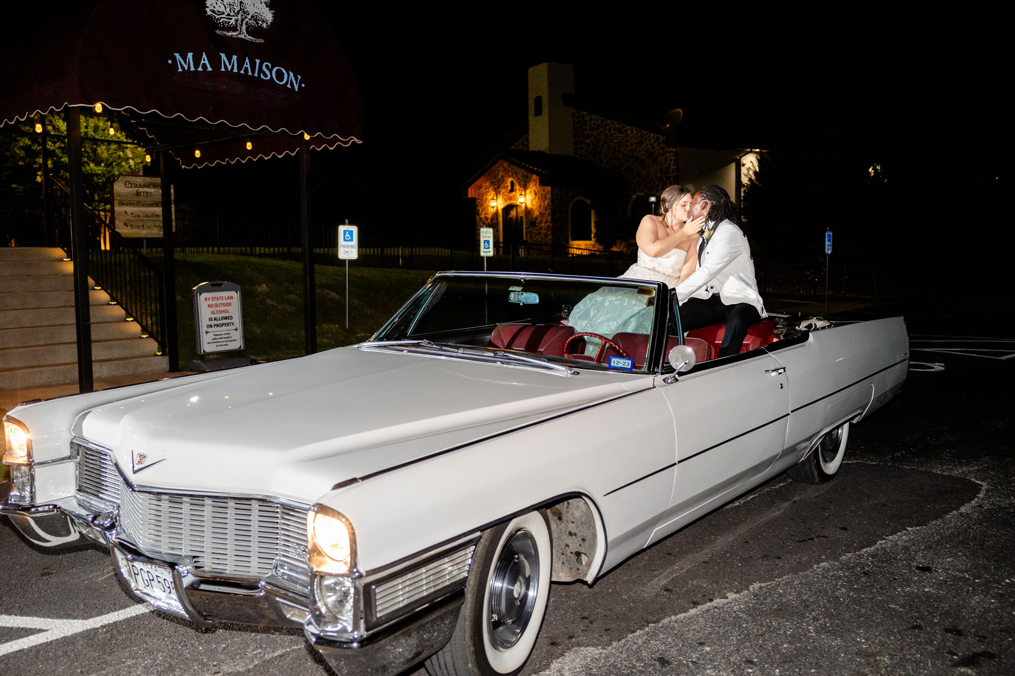 Lindsey and Nick sitting in a classic car outside of Ma Maison wedding venue
