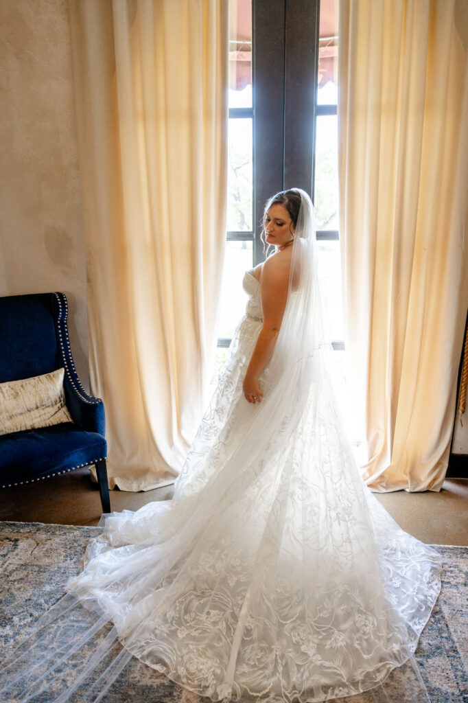 bride standing in front of window with sunshine