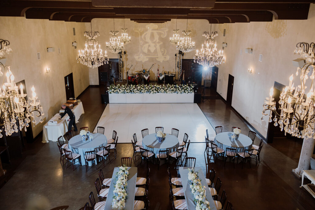 Grand ballroom reception with chandeliers and floral tablescapes at a luxury Austin wedding venue