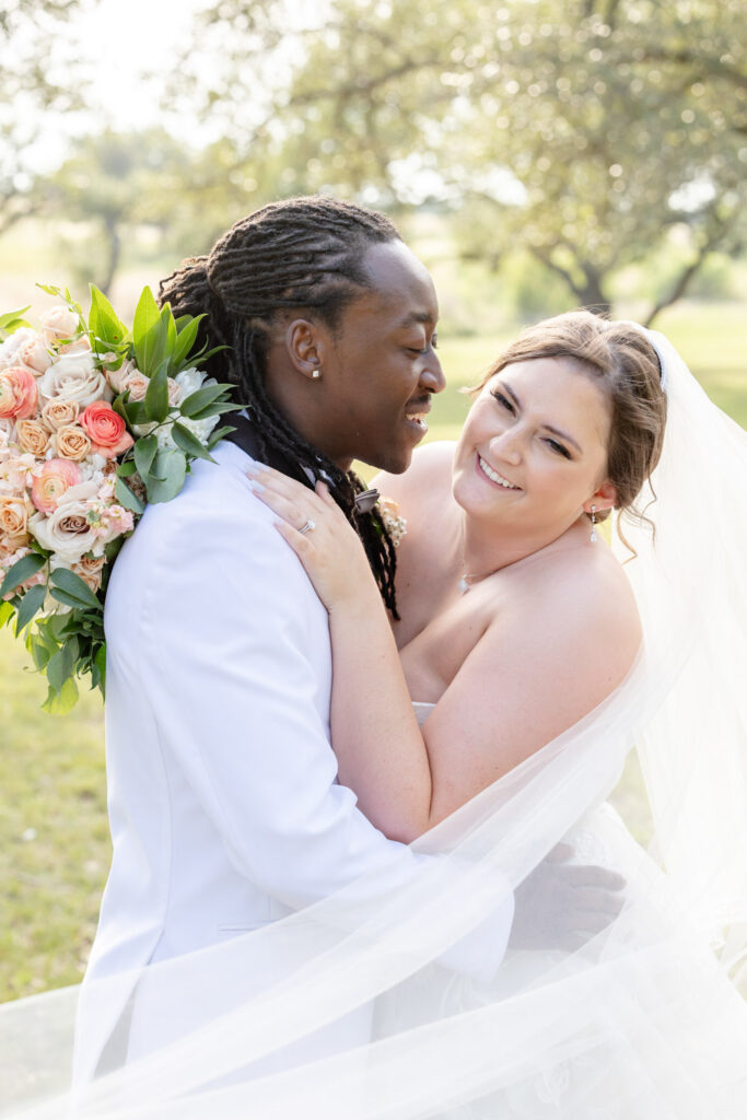 A joyful couple embraces outdoors at Ma Maison Austin Wedding Venue