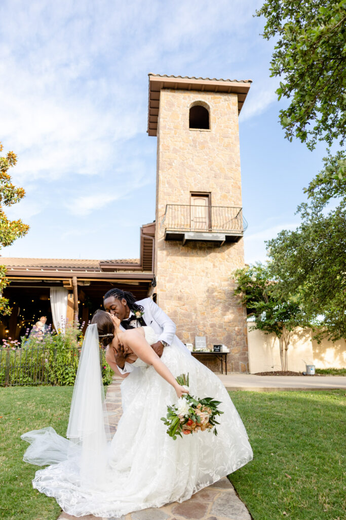 The couple shares a romantic dip and kiss in front of Ma Maison’s stone tower