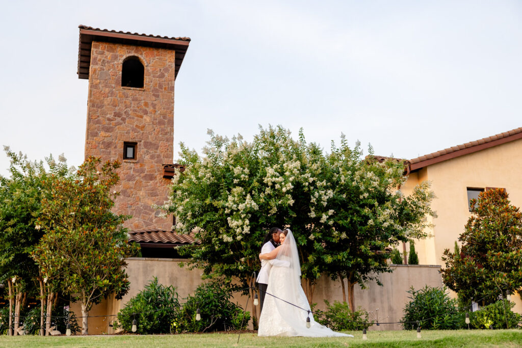 The bride and groom share an intimate hug surrounded by trees